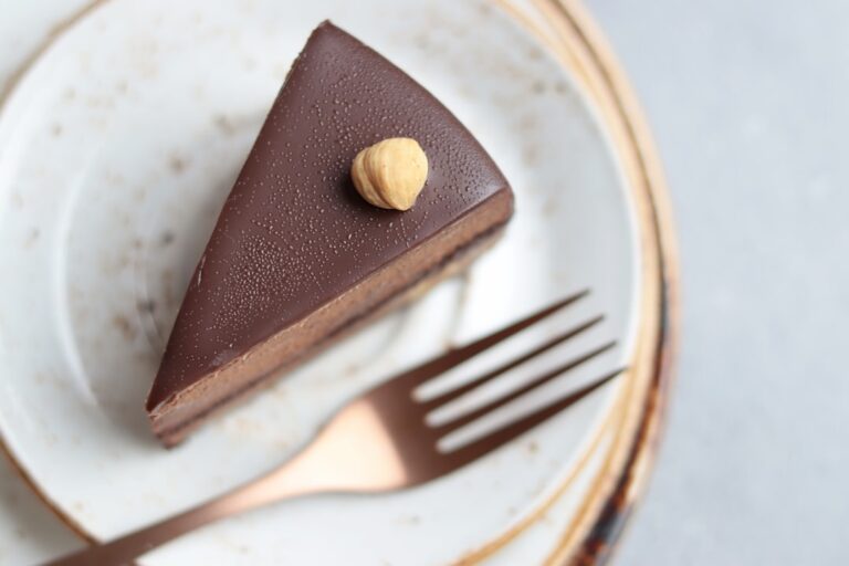 Um Pedaco De Bolo De Chocolate Em Um Prato Com Um Garfo EoFTRbUQLTs