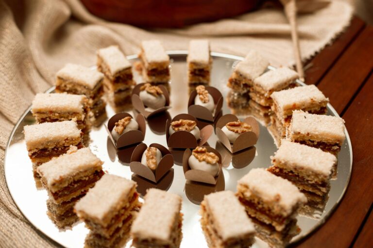 A beautiful display of Brazilian walnut layer cakes and truffles with nuts on a mirrored tray.