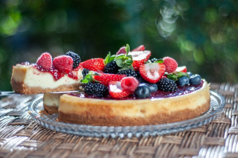 Um Cheesecake Coberto Com Bagas E Mirtilos Em Um Prato MBTbpWhycOQ