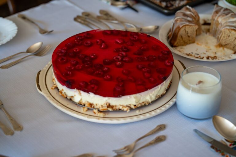 A mouth-watering raspberry cheesecake displayed on a beautifully set table, perfect for celebrations.