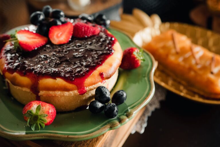 Delicious homemade cheesecake topped with fresh strawberries and blueberries, perfect for dessert lovers.