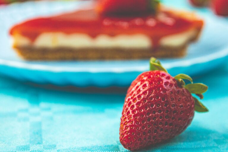 Close-up of a fresh strawberry and cheesecake slice on a blue background, Lisboa.